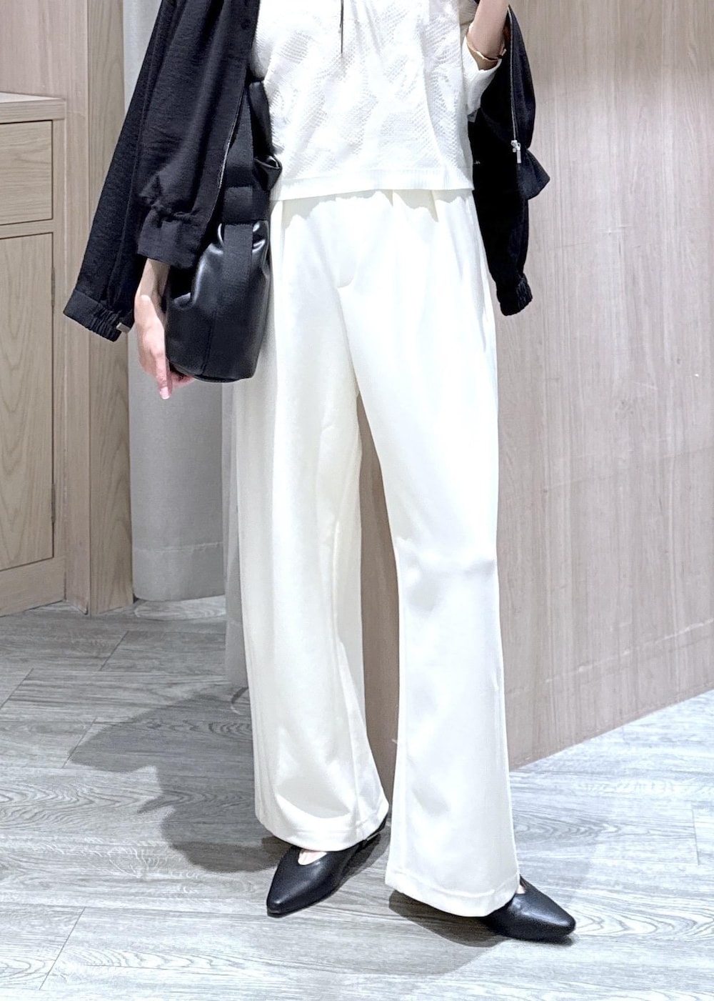 ブラック系のパンプス、ブラック系のトートバッグ、ブラック系のブルゾンを着用したレディースの春コーディネートの4枚目の写真