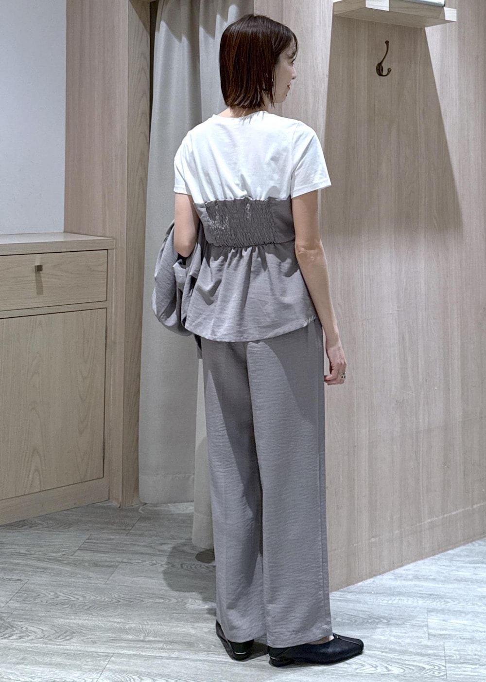 ブラック系のハンドバッグ、ブラック系のパンプス、グレー系のTシャツ/カットソーを着用したレディースの春コーディネートの7枚目の写真