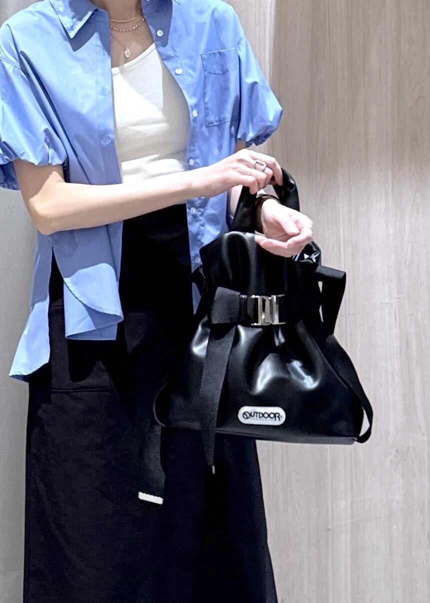 ブラック系のトートバッグ、ブラック系のスカート、ブルー系のシャツ/ブラウスを着用したレディースの春コーディネートの5枚目の写真