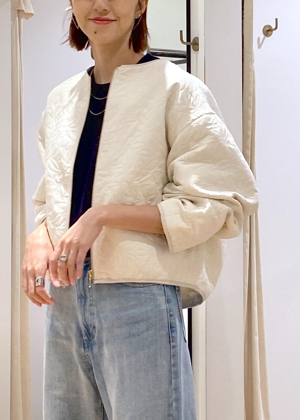 シルバー系のパンプス、ホワイト系のブルゾン、ブルー系のニット/セーターを着用したレディースの秋コーディネートの6枚目の写真