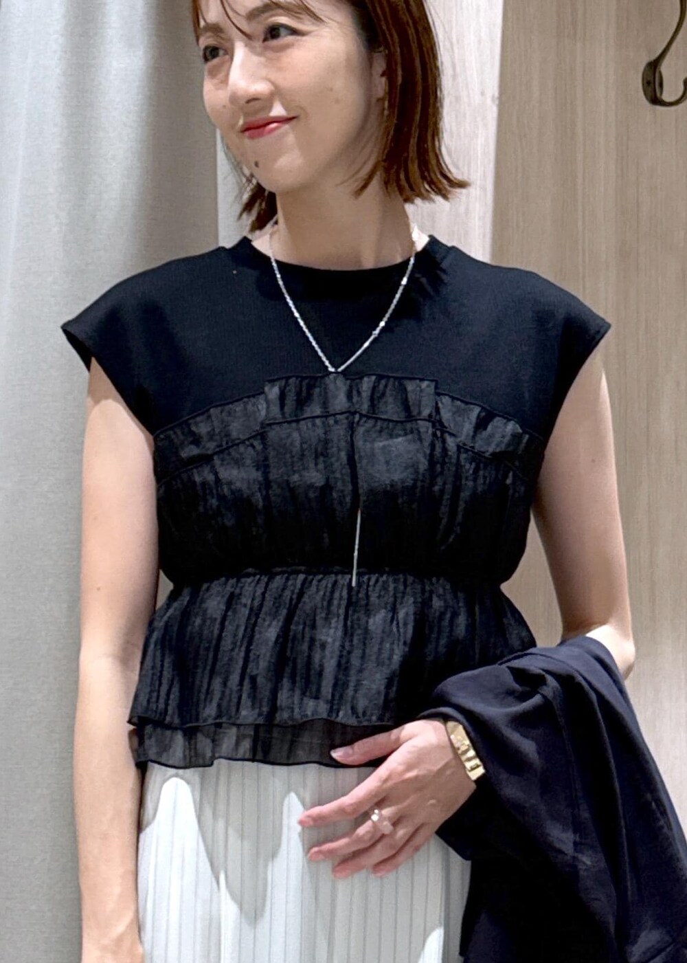 グレー系のショルダーバッグ、シルバー系のパンプス、ブラック系のTシャツ/カットソーを着用したレディースの夏コーディネートの10枚目の写真