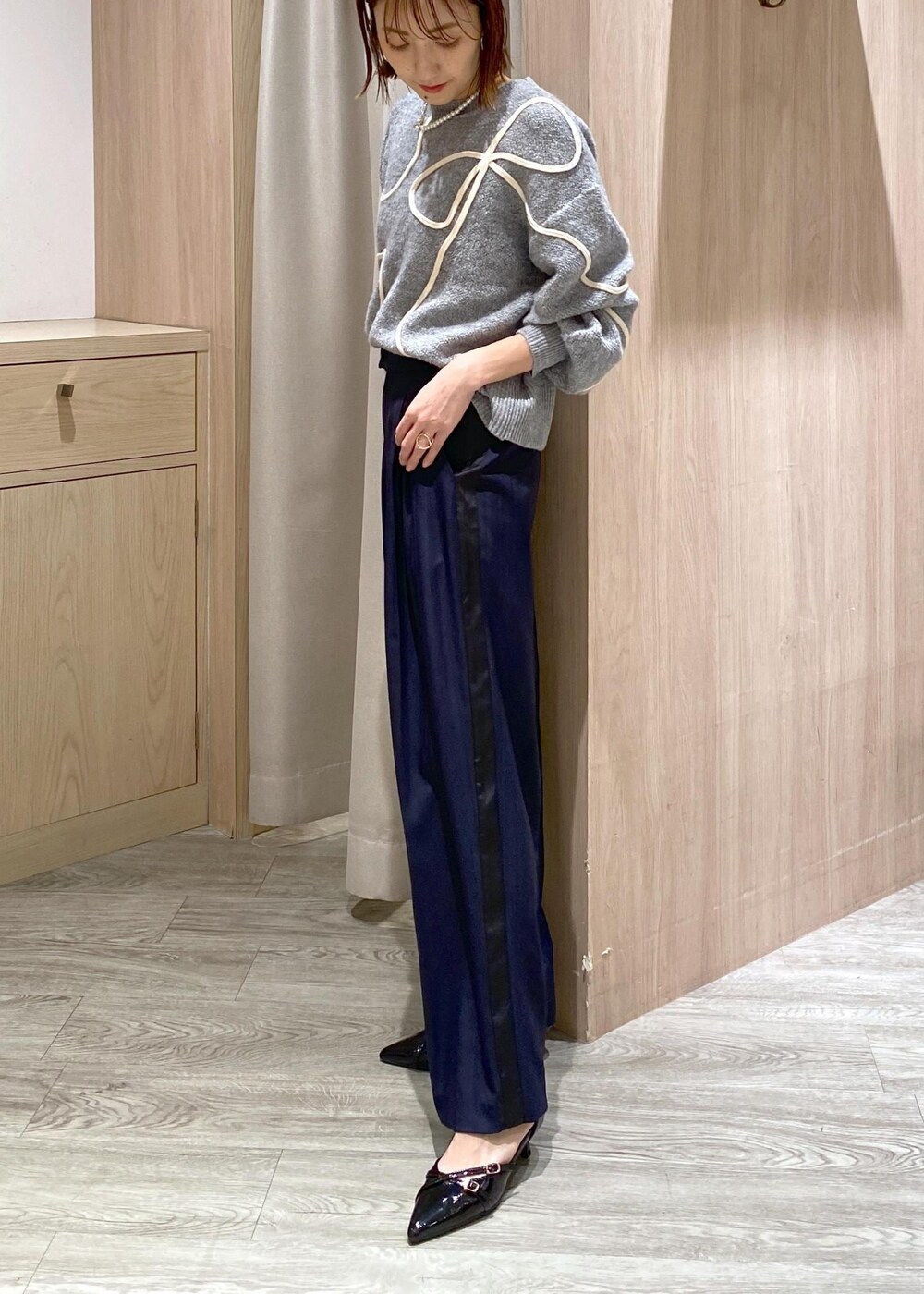 ブラック系のパンプス、グレー系のニット/セーター、ホワイト系のトートバッグを着用したレディースの冬コーディネートの7枚目の写真