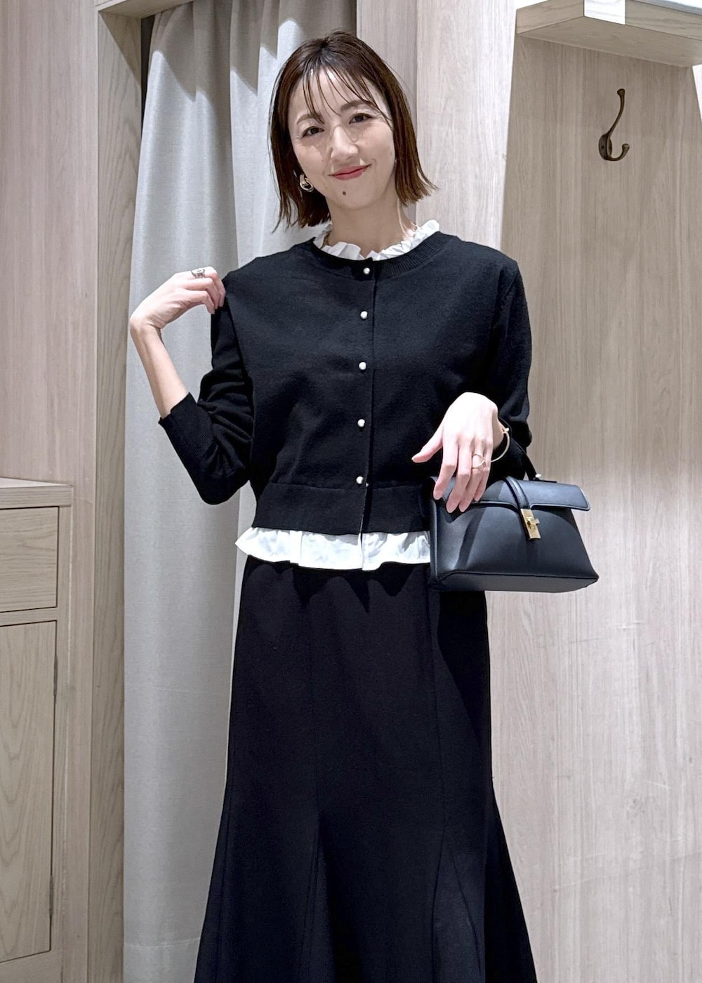 シルバー系のパンプス、ブラック系のショルダーバッグ、ブラック系のスカートを着用したレディースの冬コーディネートの10枚目の写真