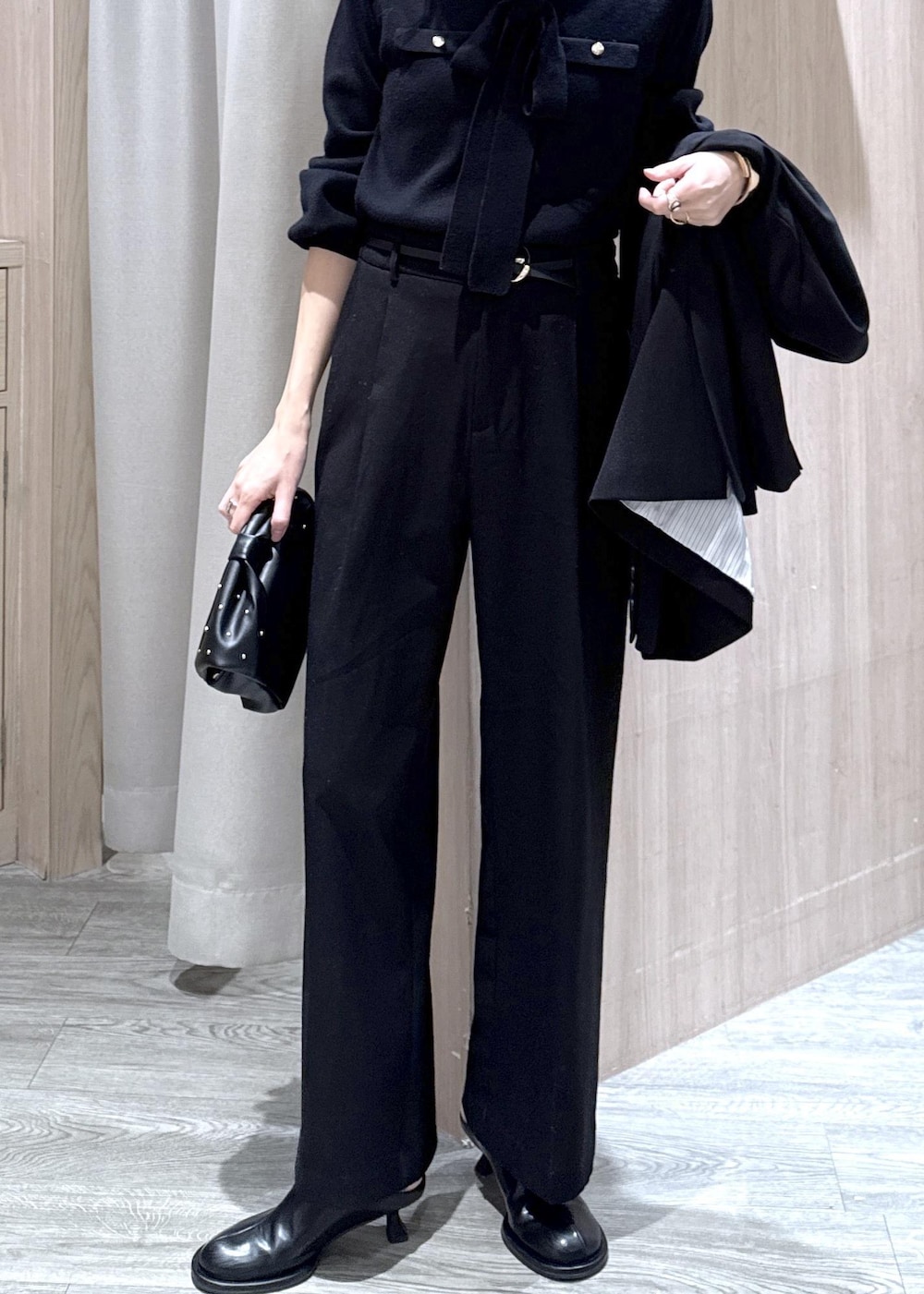 ブラック系のスラックス、ブラック系のテーラードジャケット、ブラック系のショルダーバッグを着用したレディースの冬コーディネートの6枚目の写真