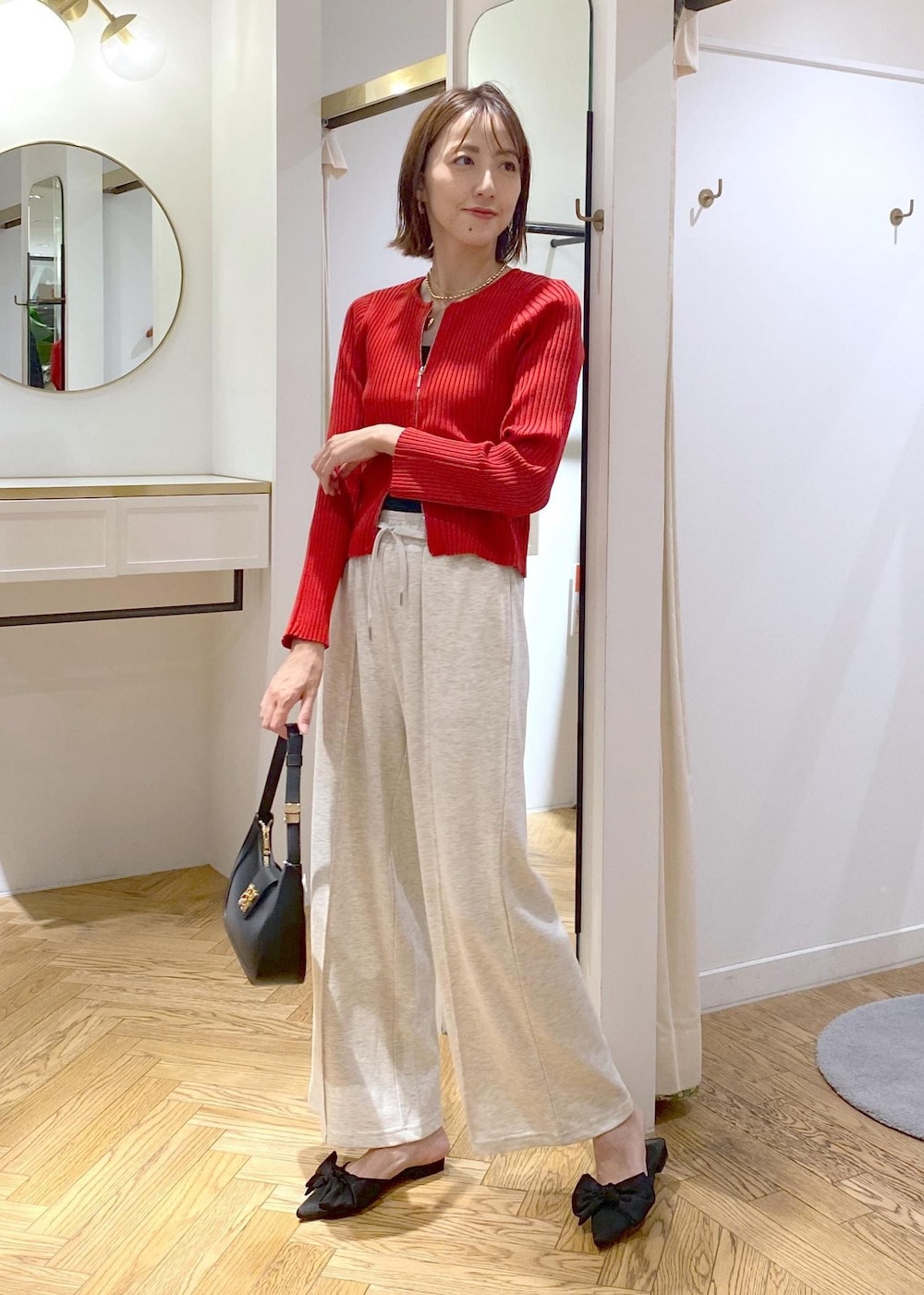 ブラック系のキャミソール、ブラック系のハンドバッグ、ホワイト系のその他パンツを着用したレディースの秋コーディネートの10枚目の写真