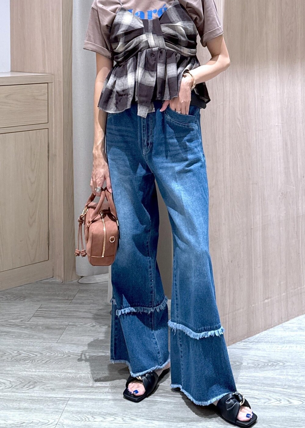 ブラック系のサンダル、ブルー系のデニムパンツ、ブラック系のキャミソールを着用したレディースの夏コーディネートの5枚目の写真