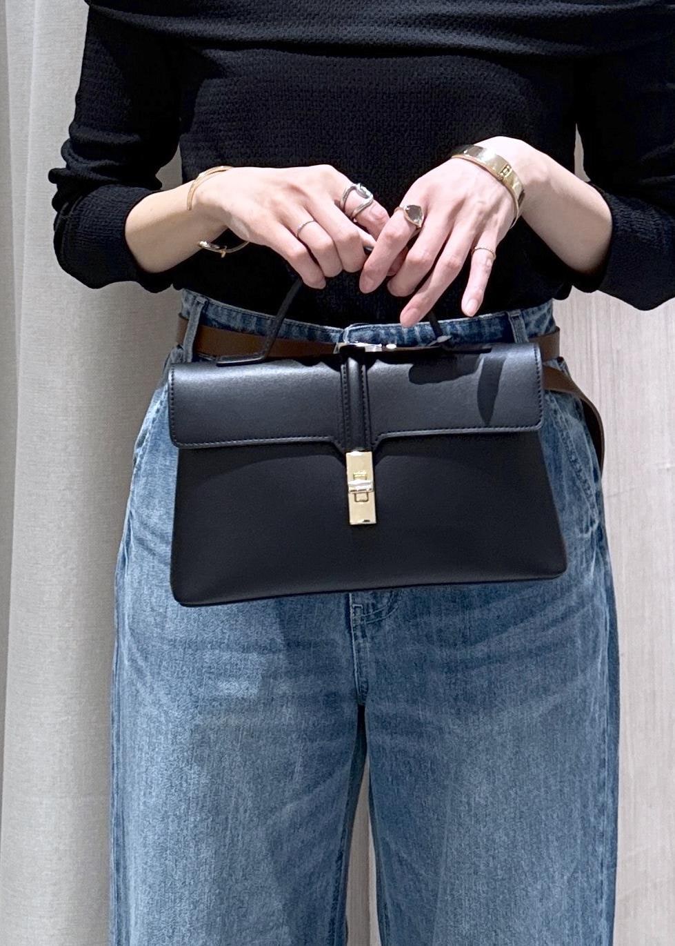 ブラック系のショルダーバッグ、ブルー系のデニムパンツ、ブラック系のTシャツ/カットソーを着用したレディースの春コーディネートの6枚目の写真