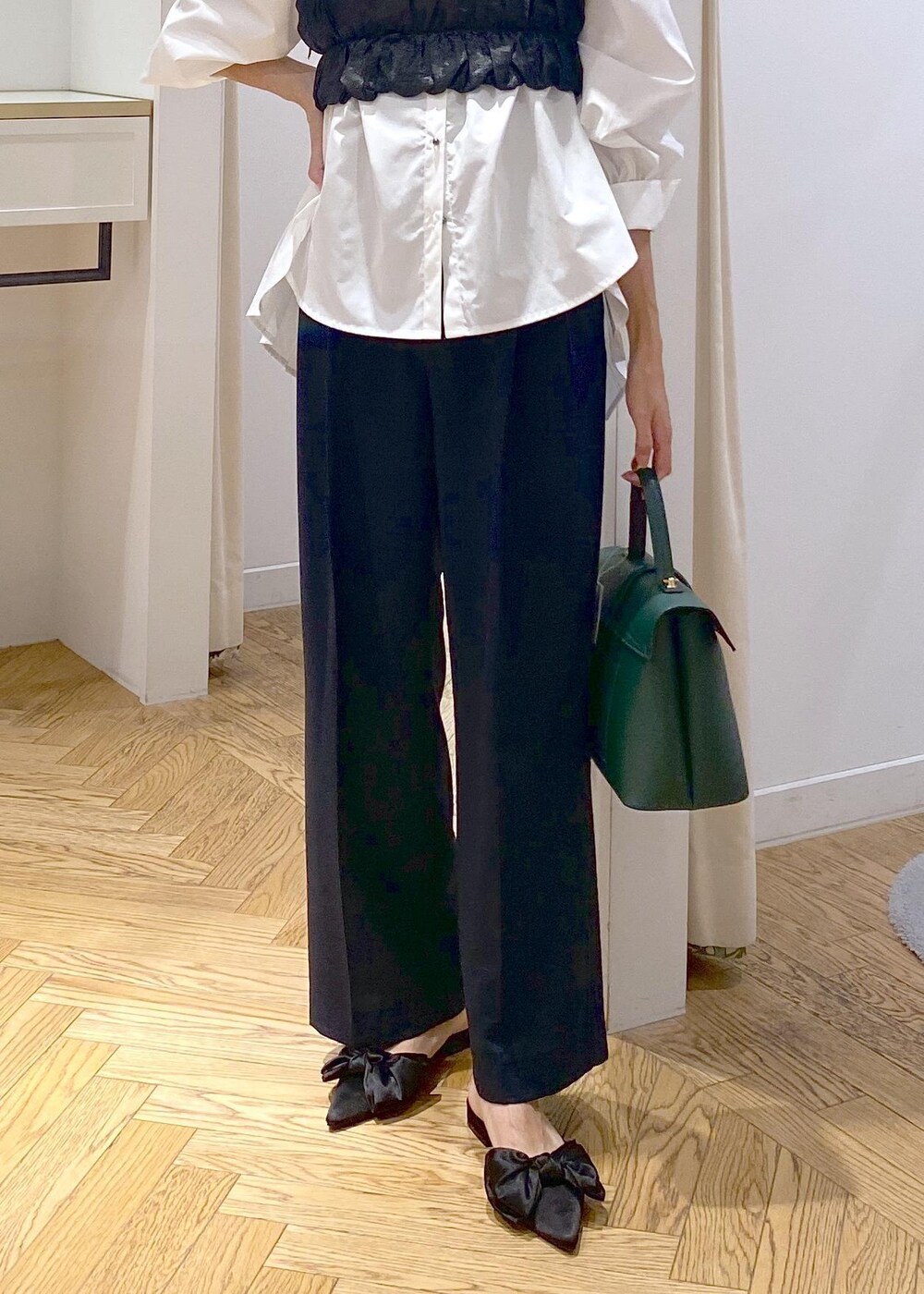 ブルー系のスラックス、ホワイト系のシャツ/ブラウス、グリーン系のハンドバッグを着用したレディースの秋コーディネートの5枚目の写真