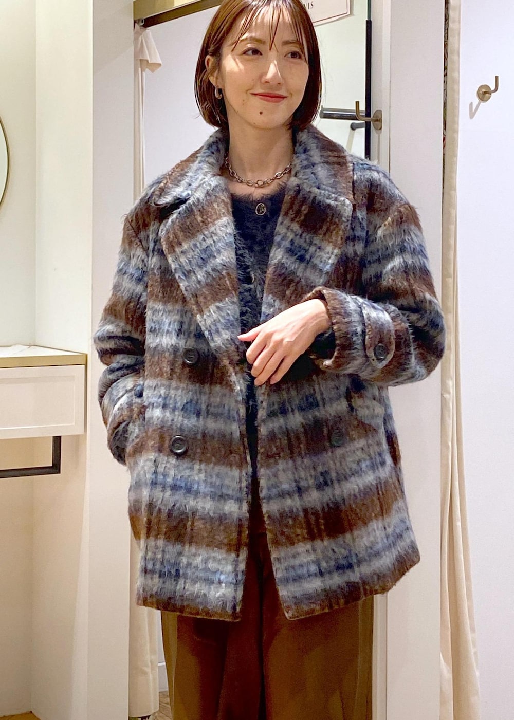 ブラック系のパンプス、グレー系のカーディガン/ボレロ、ブラウン系のピーコートを着用したレディースの冬コーディネートの6枚目の写真