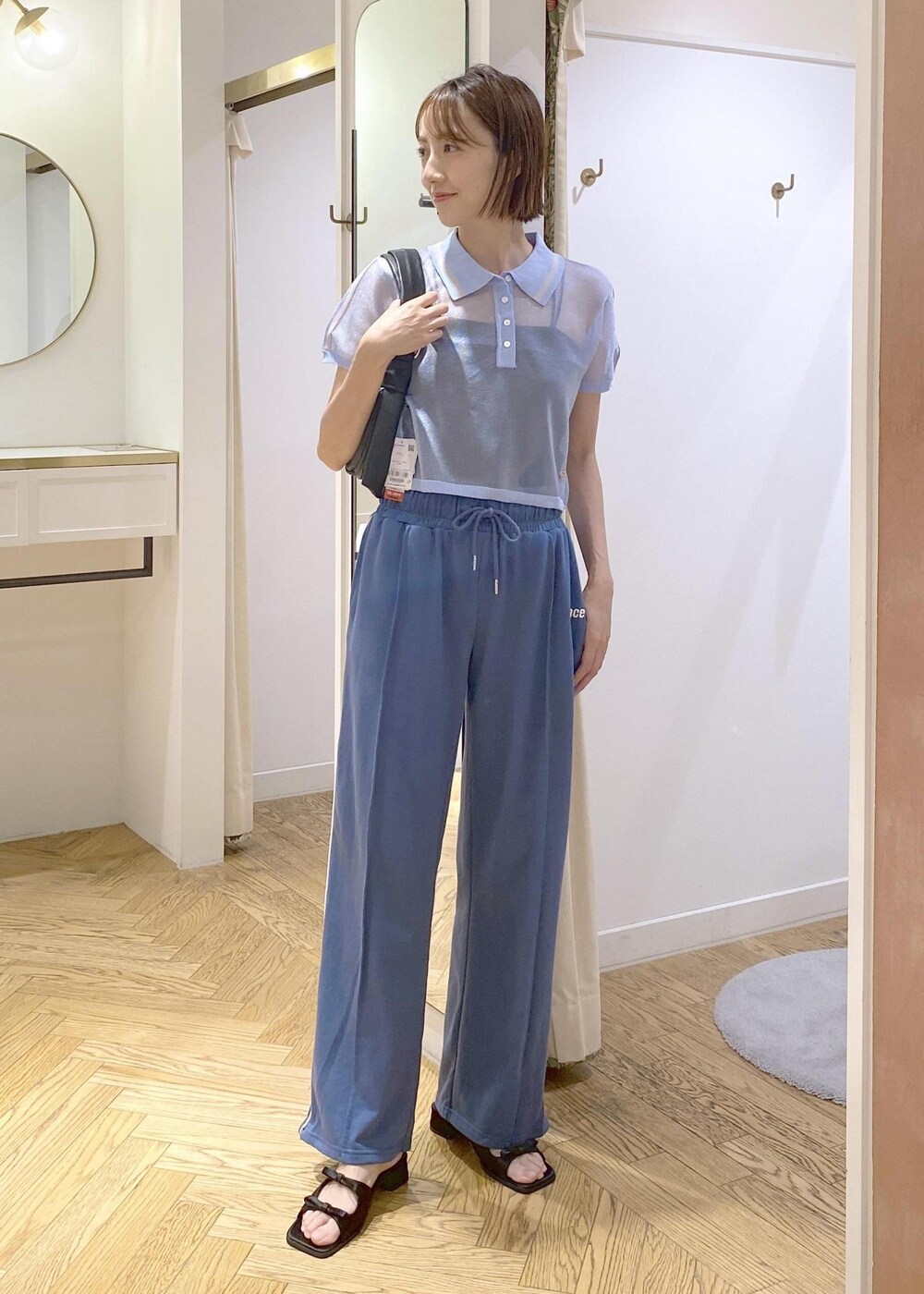 ブラック系のハンドバッグ、ブラック系のサンダル、ブラック系のキャミソールを着用したレディースの夏コーディネートの7枚目の写真