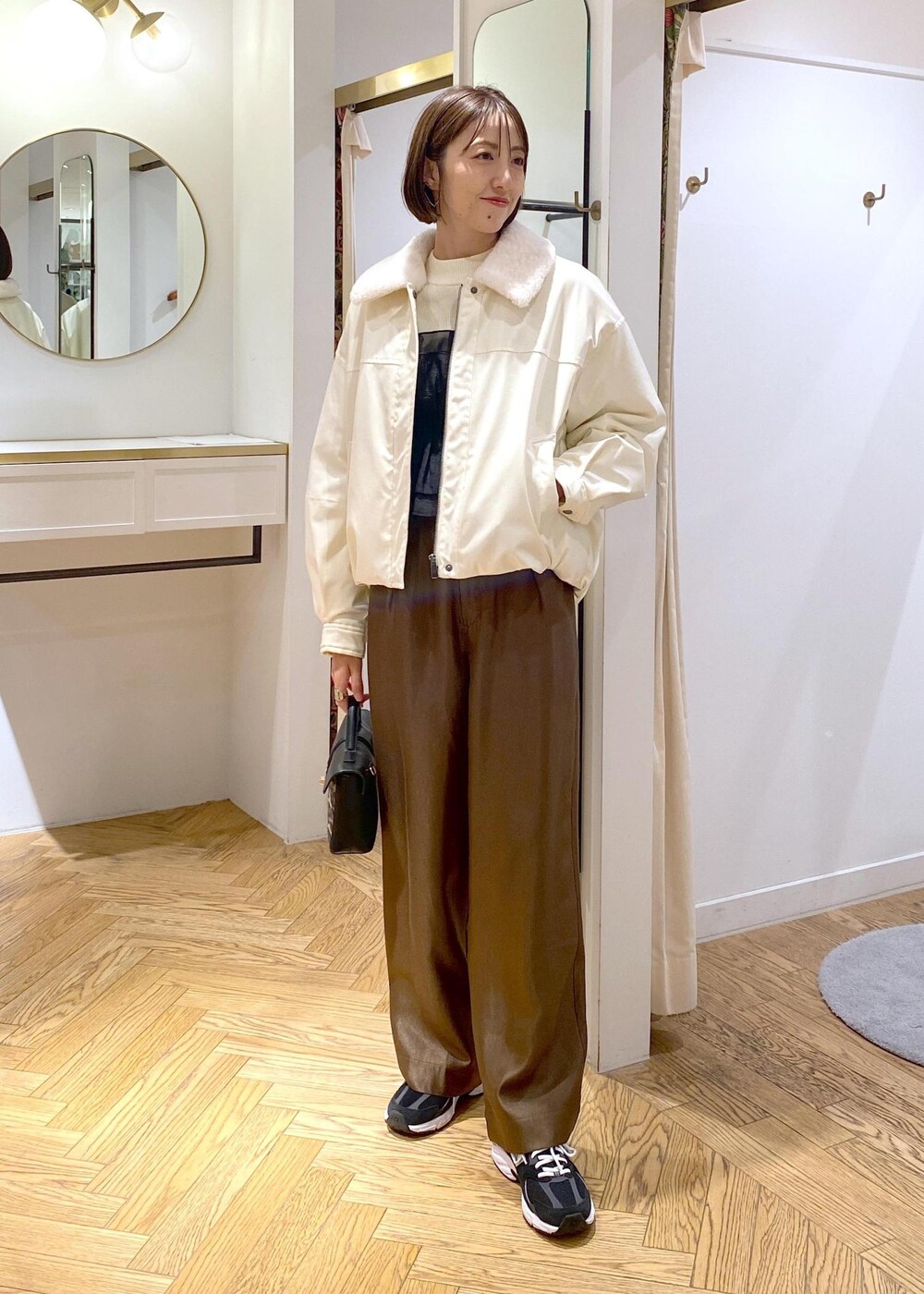 ホワイト系のブルゾン、ホワイト系のニット/セーター、ブラウン系のその他パンツを着用したレディースの冬コーディネートの2枚目の写真