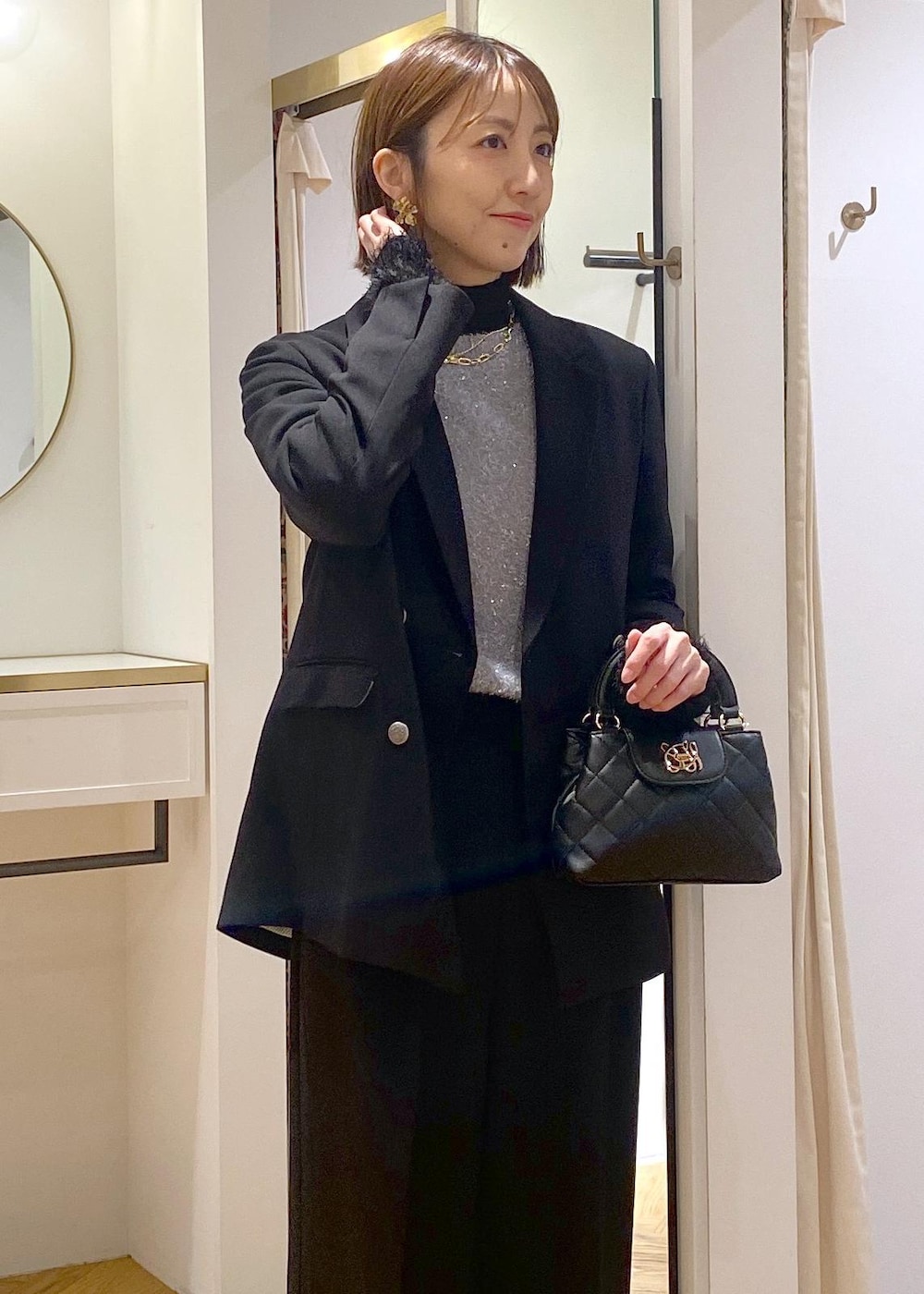 ブラック系のニット/セーター、ブラック系のスラックス、ブラック系のテーラードジャケットを着用したレディースの冬コーディネートの7枚目の写真