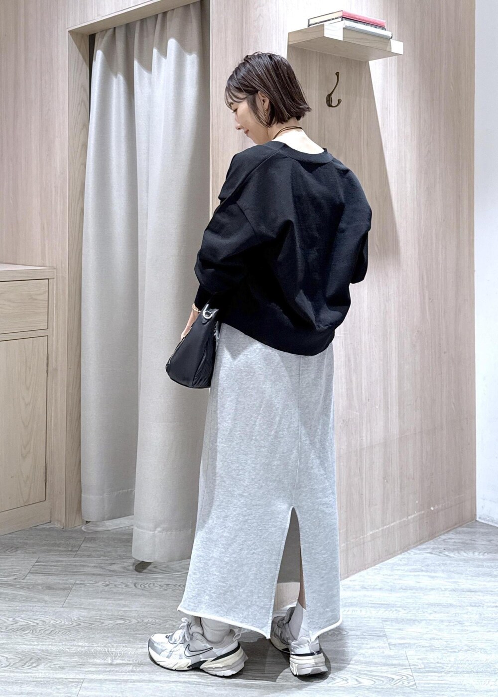 グレー系のスカート、ホワイト系のキャミソール、ブラック系のカーディガン/ボレロを着用したレディースの秋コーディネートの4枚目の写真