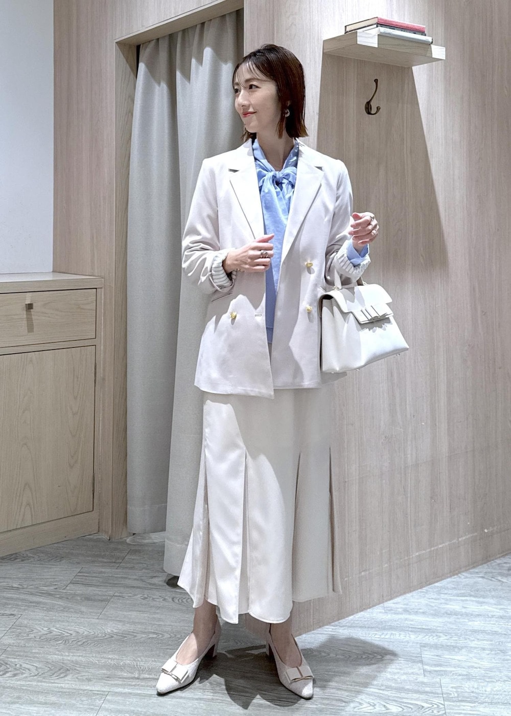 ベージュ系のパンプス、ベージュ系のテーラードジャケット、ブルー系のシャツ/ブラウスを着用したレディースの冬コーディネートの3枚目の写真