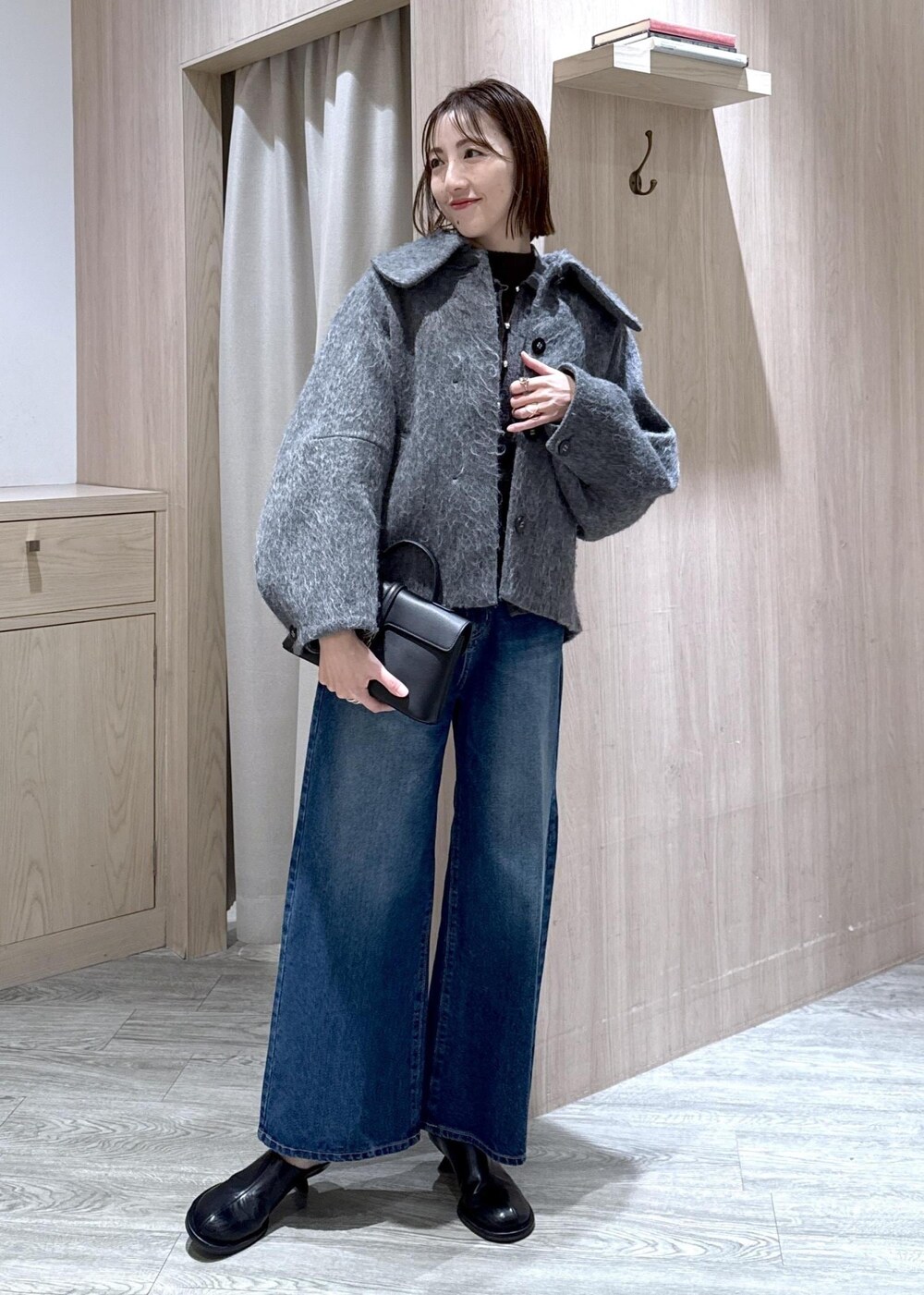 ブラック系のショルダーバッグ、ブルー系のデニムパンツ、グレー系のブルゾンを着用したレディースの冬コーディネートの10枚目の写真