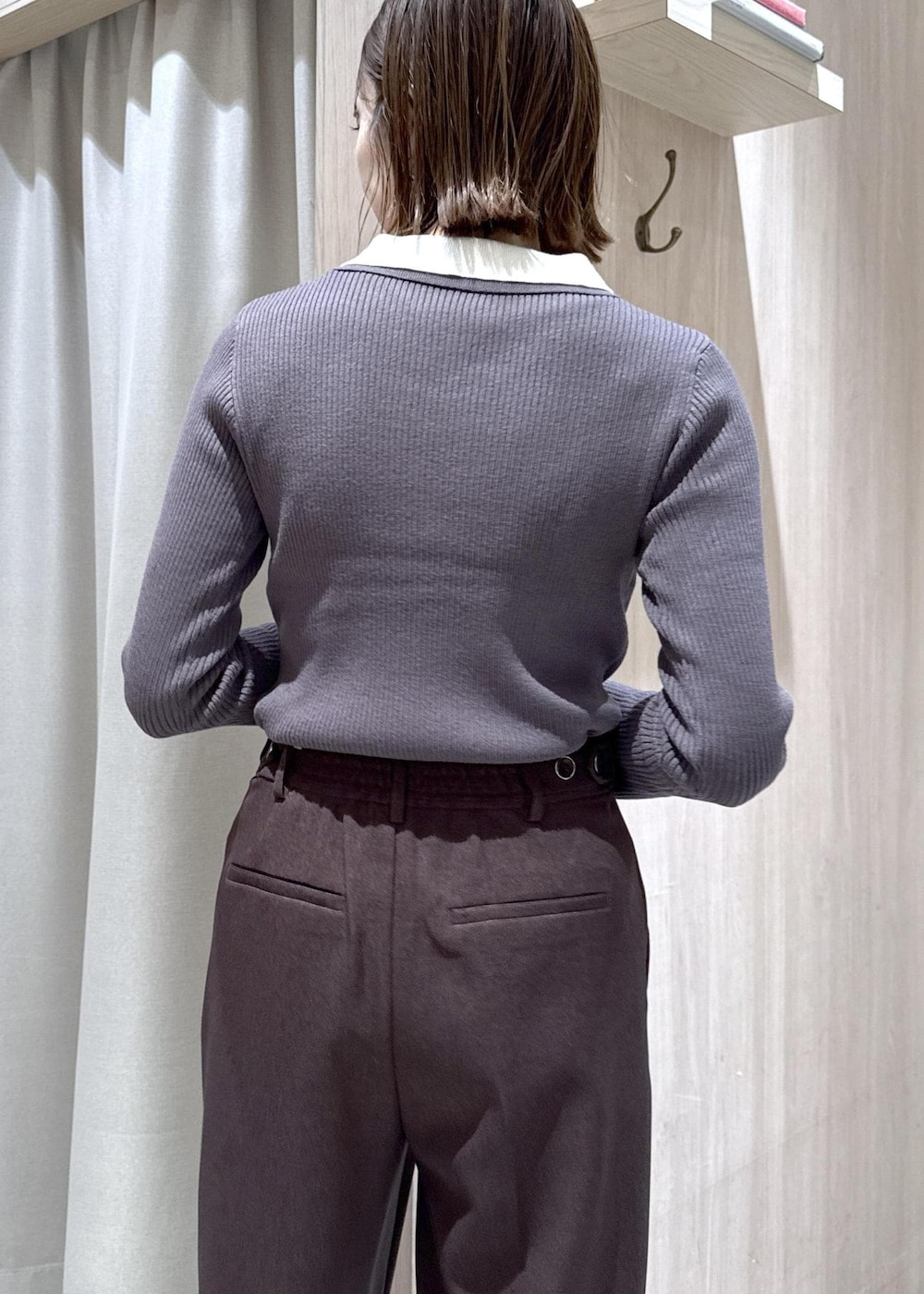 ブラウン系のスラックス、ブラック系のショルダーバッグ、ホワイト系のダウンジャケット/コートを着用したレディースの冬コーディネートの8枚目の写真