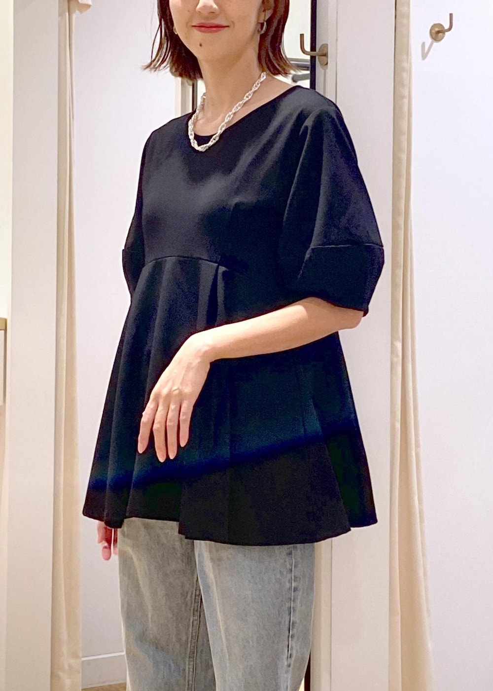 ブラック系のブーツ、ブラック系のTシャツ/カットソー、ブルー系のデニムパンツを着用したレディースの秋コーディネートの8枚目の写真