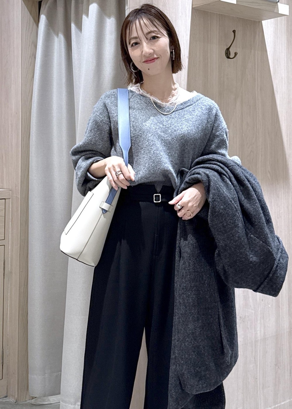 ベージュ系のトートバッグ、グレー系のその他アウター、ブラック系のその他パンツを着用したレディースの冬コーディネートの4枚目の写真