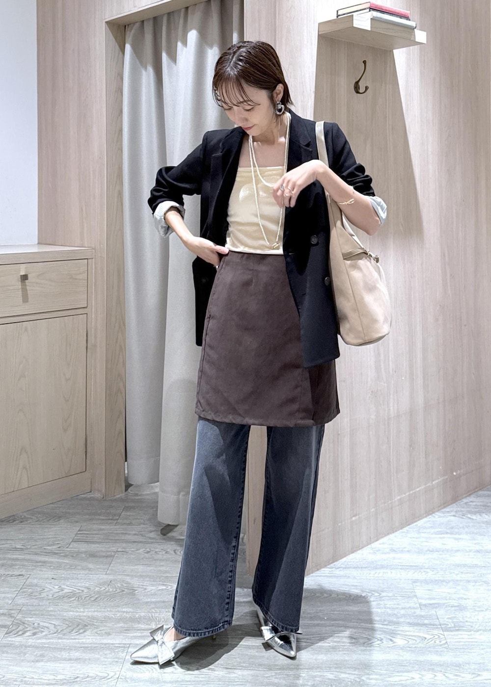 シルバー系のパンプス、ベージュ系のショルダーバッグ、ブラック系のテーラードジャケットを着用したレディースの秋コーディネートの2枚目の写真