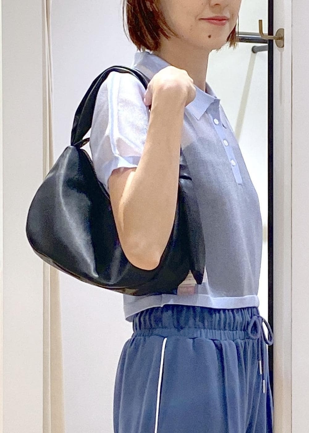 ブラック系のハンドバッグ、ブラック系のサンダル、ブラック系のキャミソールを着用したレディースの夏コーディネートの5枚目の写真