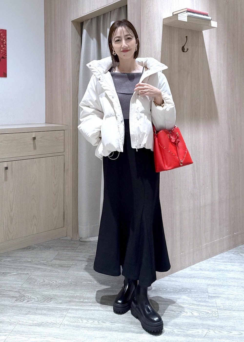 ブラック系のスカート、ブラック系のブーツ、グレー系のニット/セーターを着用したレディースの冬コーディネートの5枚目の写真