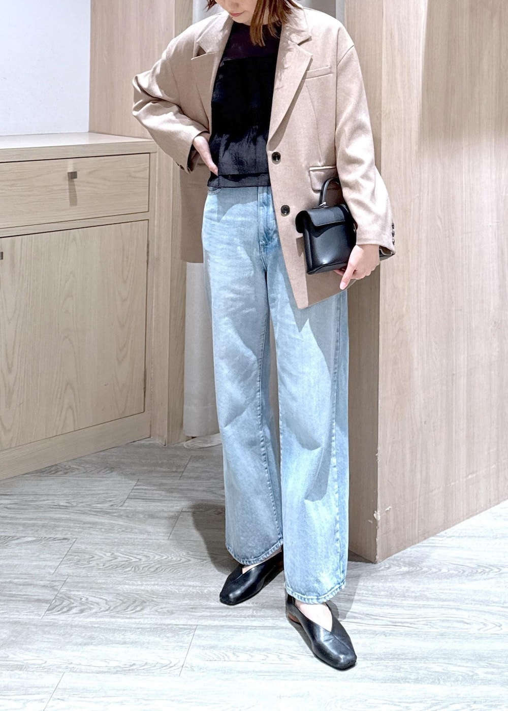 ブラック系のショルダーバッグ、ブルー系のデニムパンツ、イエロー系のテーラードジャケットを着用したレディースの春コーディネートの6枚目の写真