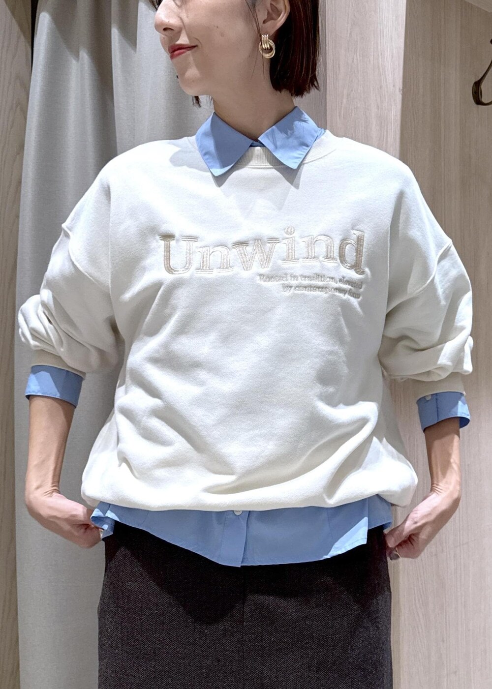 グレー系のショルダーバッグ、ブラック系のブーツ、ブラウン系のスカートを着用したレディースの秋コーディネートの6枚目の写真