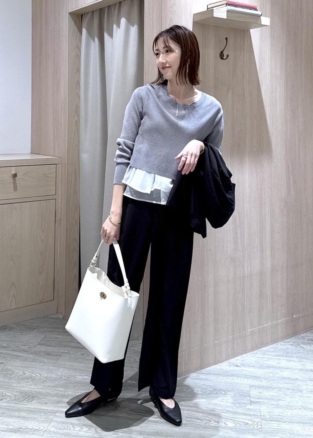 ブラック系のパンプス、グレー系のニット/セーター、ブラック系のその他パンツを着用したレディースの春コーディネートの2枚目の写真
