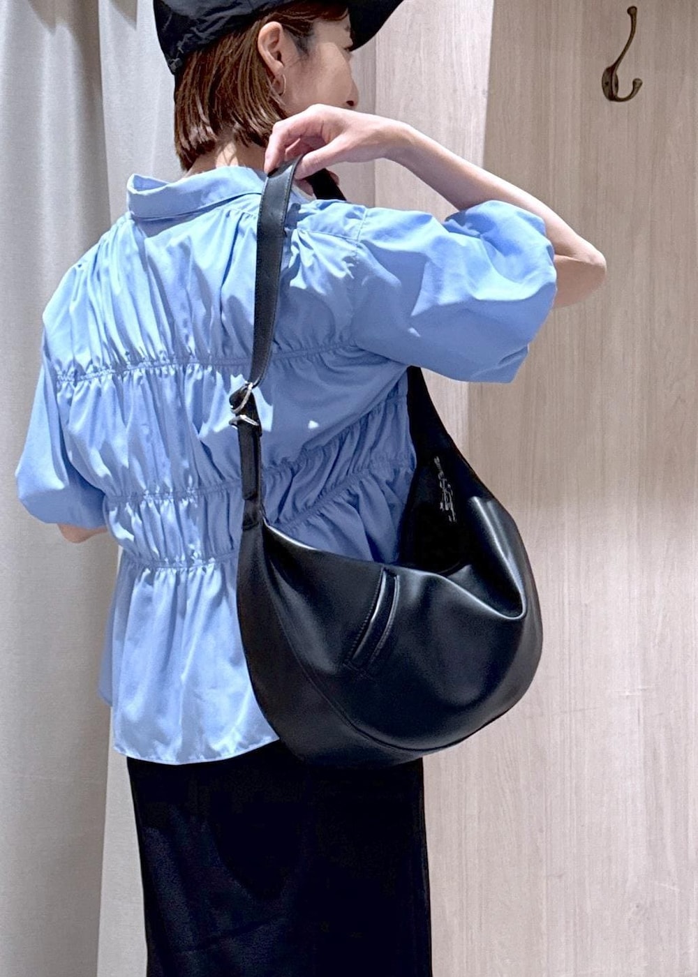 ブラック系のショルダーバッグ、ブラック系のスカート、ホワイト系のTシャツ/カットソーを着用したレディースの春コーディネートの5枚目の写真