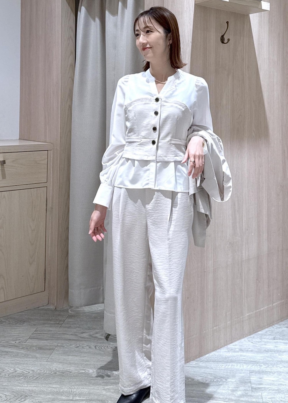 ブラック系のショルダーバッグ、ブラック系のパンプス、ホワイト系のシャツ/ブラウスを着用したレディースの春コーディネートの7枚目の写真