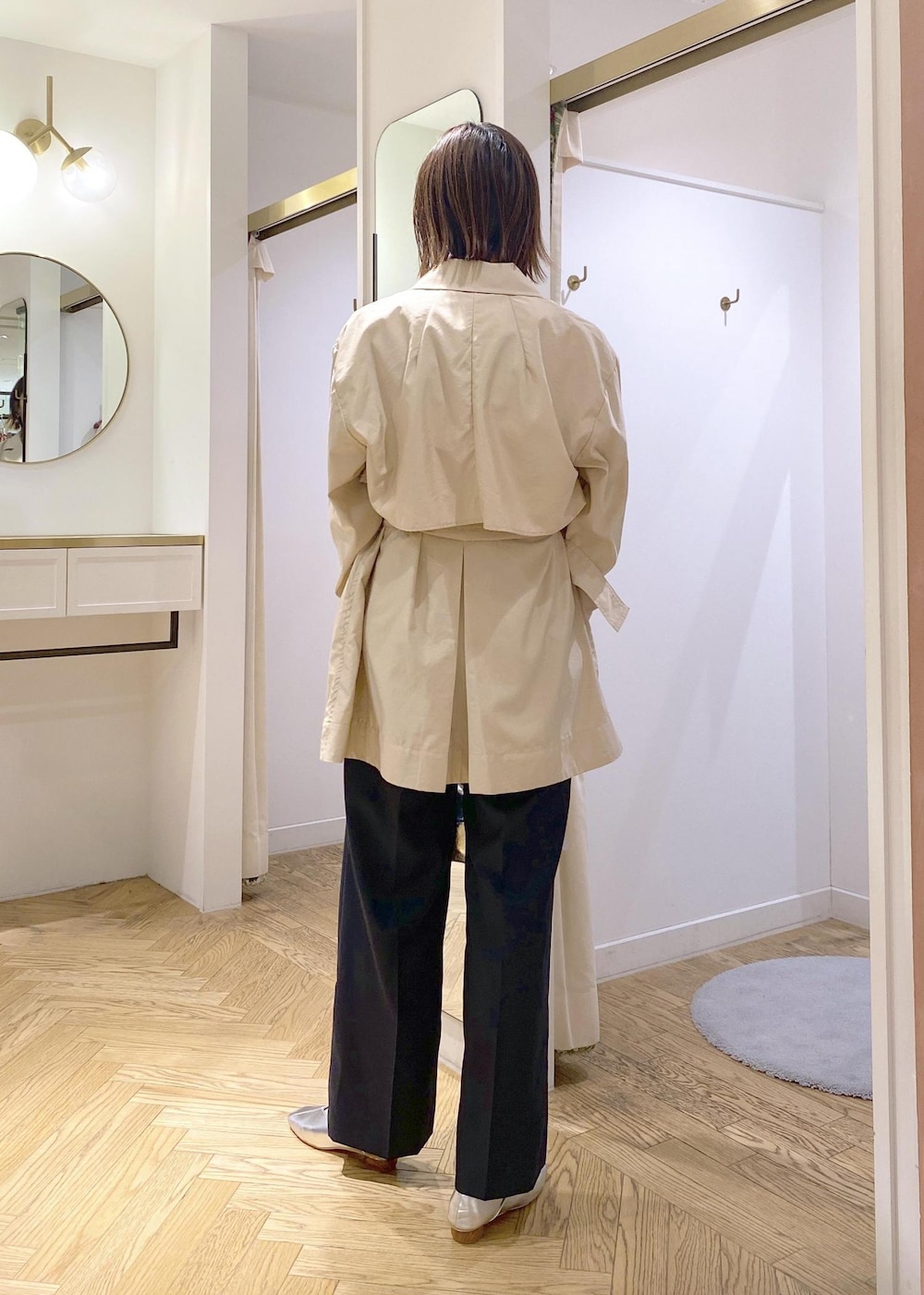 シルバー系のパンプス、ベージュ系のトレンチコート、シルバー系のハンドバッグを着用したレディースの春コーディネートの3枚目の写真