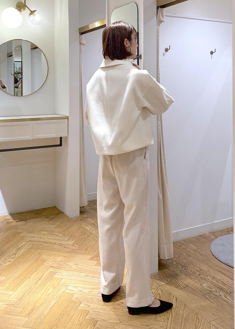 ブルー系のハンドバッグ、ホワイト系のブルゾン、ブラック系のパンプスを着用したレディースの冬コーディネートの5枚目の写真