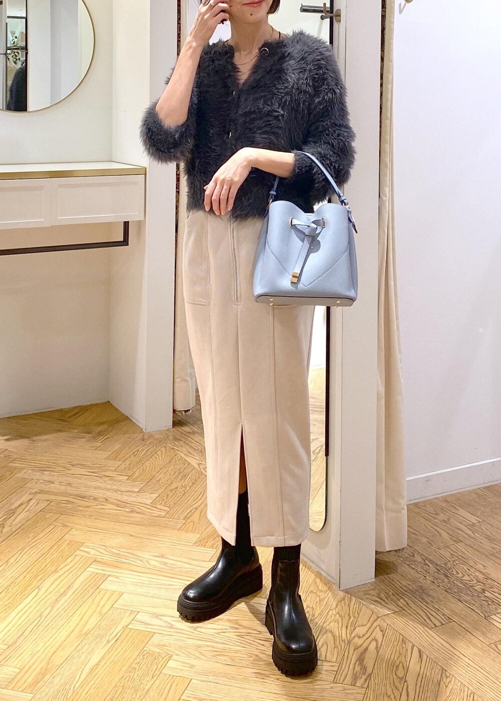 ブラック系のブーツ、ベージュ系のスカート、グレー系のカーディガン/ボレロを着用したレディースの冬コーディネートの4枚目の写真
