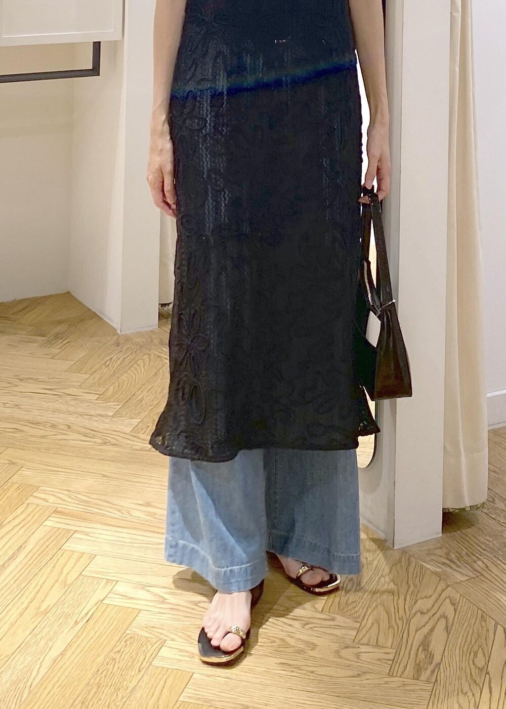 ブラック系のキャミソール、ブラック系のサンダル、ブラック系のハンドバッグを着用したレディースの夏コーディネートの6枚目の写真