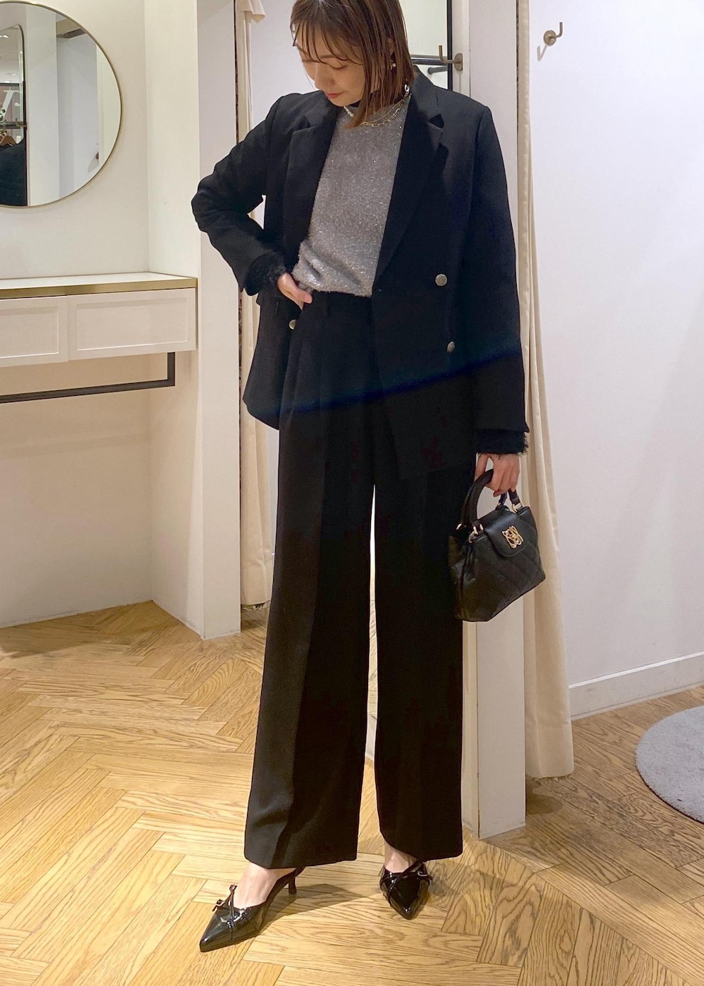 ブラック系のニット/セーター、ブラック系のスラックス、ブラック系のテーラードジャケットを着用したレディースの冬コーディネートの6枚目の写真