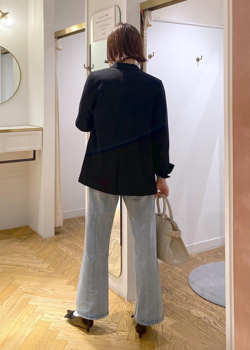 ブラック系のパンプス、グレー系のニット/セーター、ブルー系のデニムパンツを着用したレディースの冬コーディネートの3枚目の写真