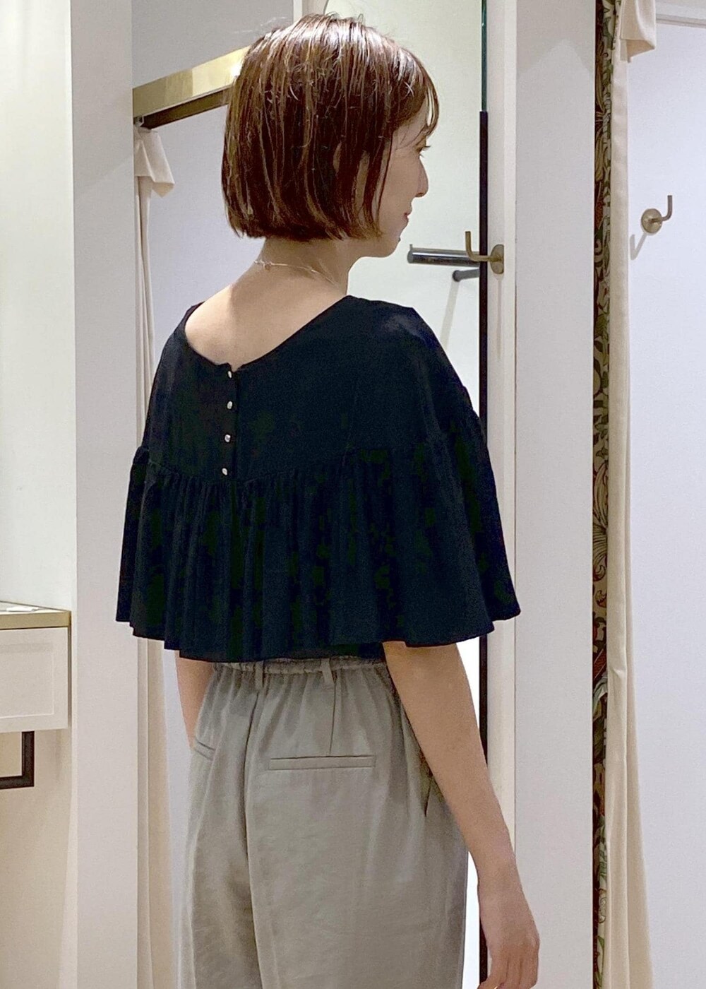 グリーン系のスラックス、ホワイト系のサンダル、ホワイト系のハンドバッグを着用したレディースの夏コーディネートの7枚目の写真