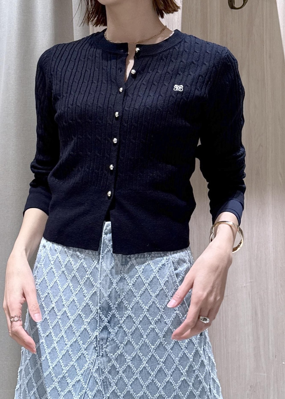 ホワイト系のショルダーバッグ、ブルー系のカーディガン/ボレロ、ブルー系のデニムスカートを着用したレディースの冬コーディネートの7枚目の写真