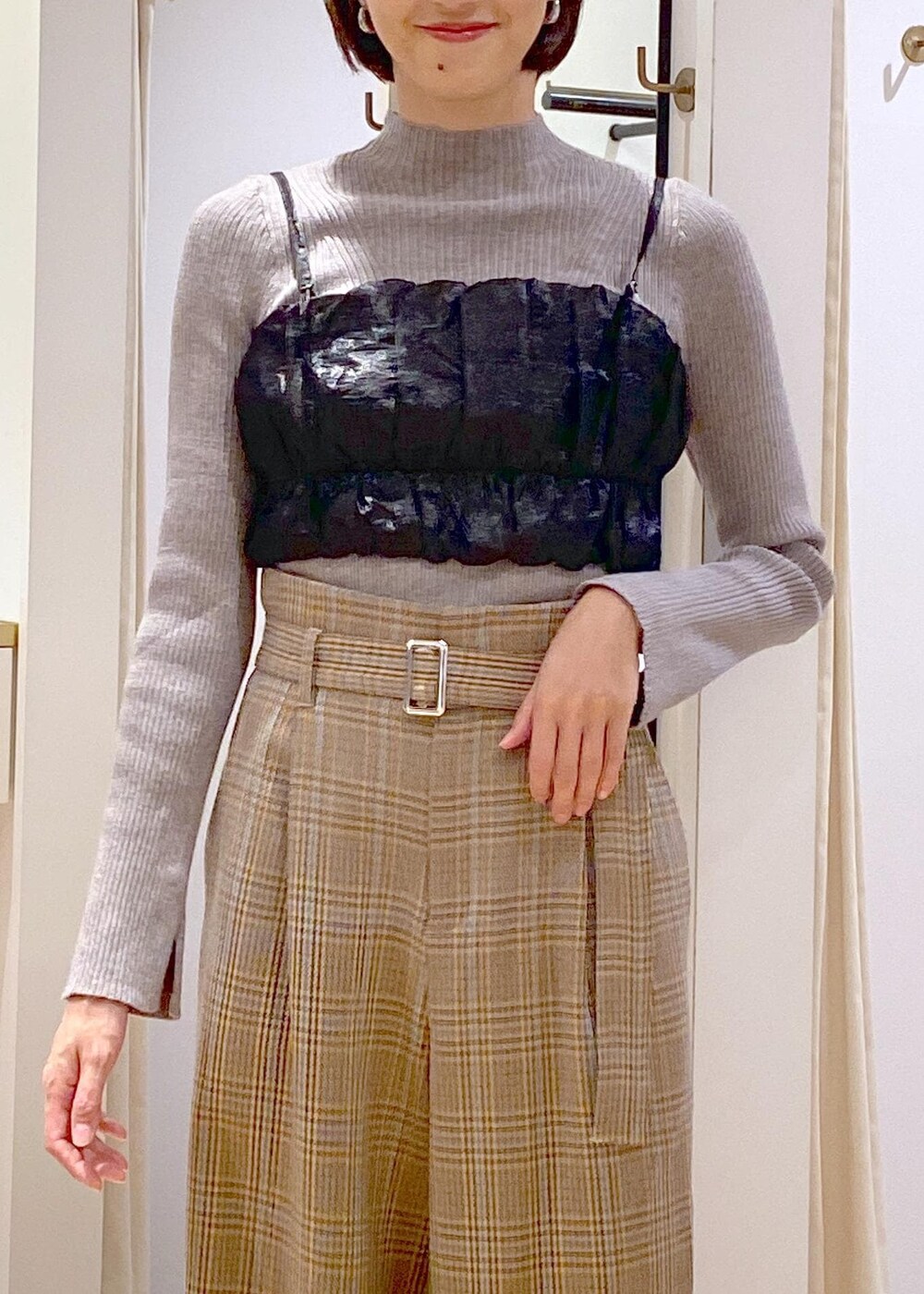 ブラック系のショルダーバッグ、ブラック系のブーツ、ベージュ系のスラックスを着用したレディースの秋コーディネートの6枚目の写真