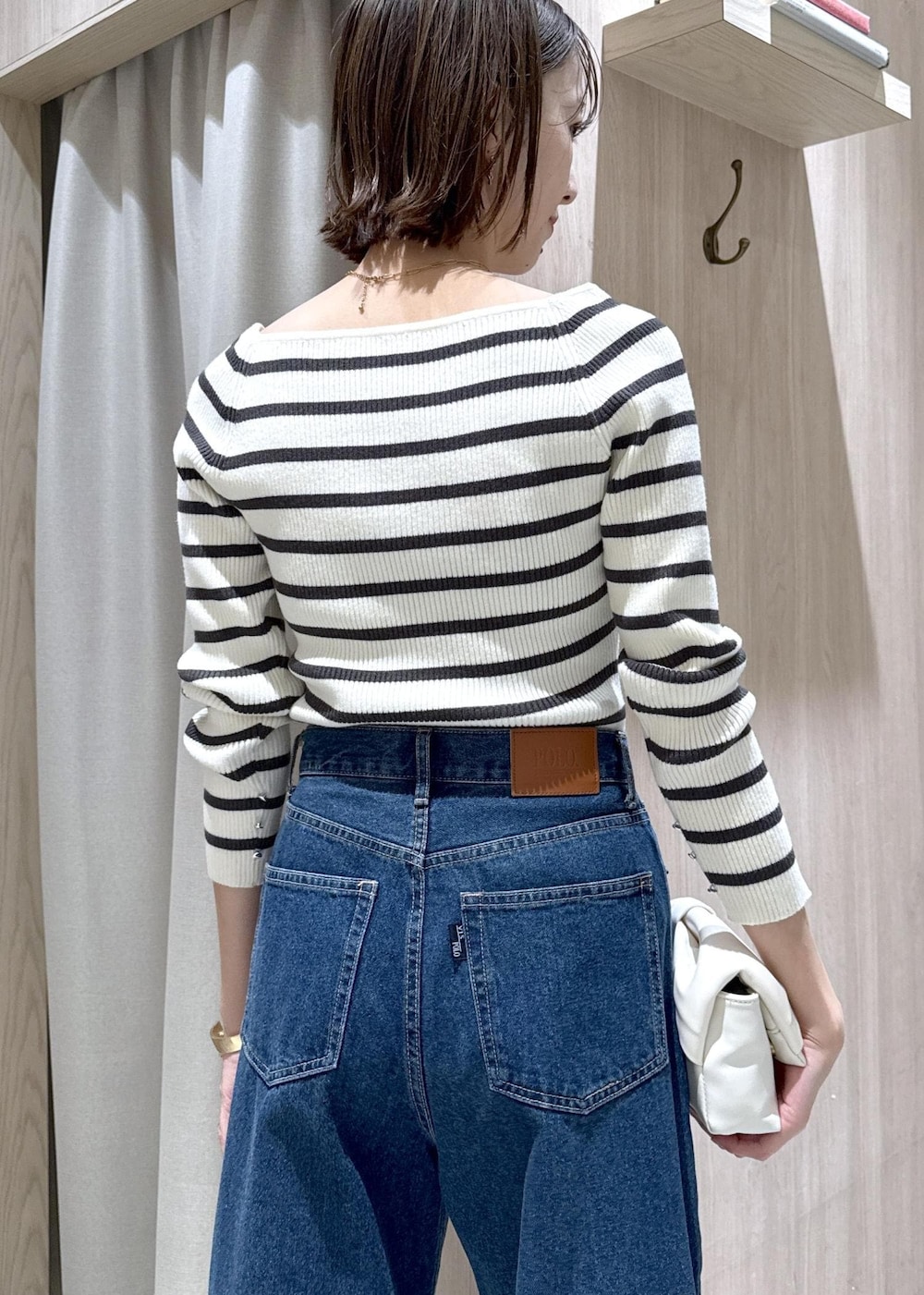 ブルー系のデニムパンツ、グレー系のテーラードジャケット、ホワイト系のショルダーバッグを着用したレディースの冬コーディネートの10枚目の写真