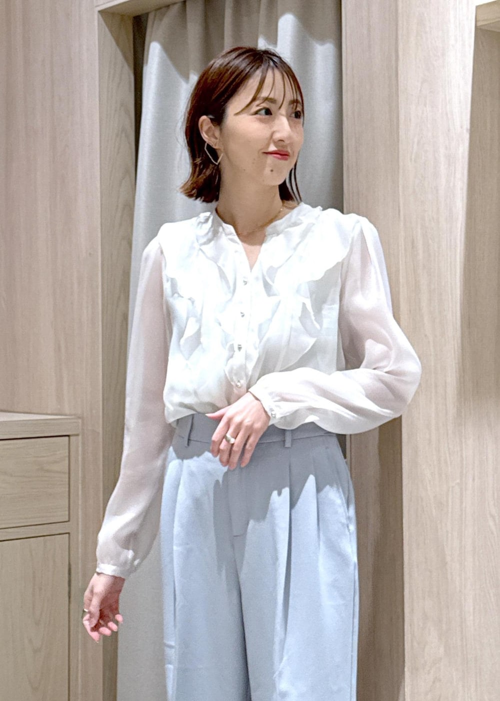 ブラック系のショルダーバッグ、ブルー系のスラックス、ベージュ系のテーラードジャケットを着用したレディースの春コーディネートの9枚目の写真