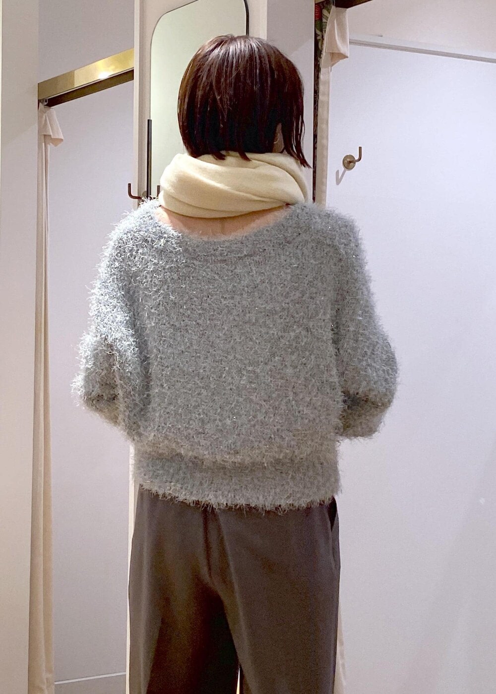 グレー系のスラックス、ブルー系のショルダーバッグ、ブラック系のパンプスを着用したレディースの冬コーディネートの8枚目の写真