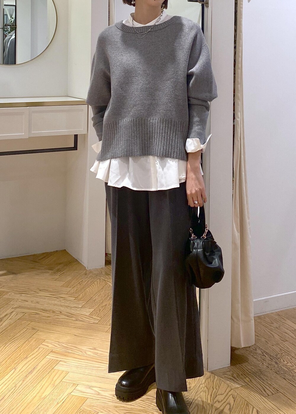 ブラック系のブーツ、ホワイト系のシャツ/ブラウス、グレー系のニット/セーターを着用したレディースの冬コーディネートの4枚目の写真