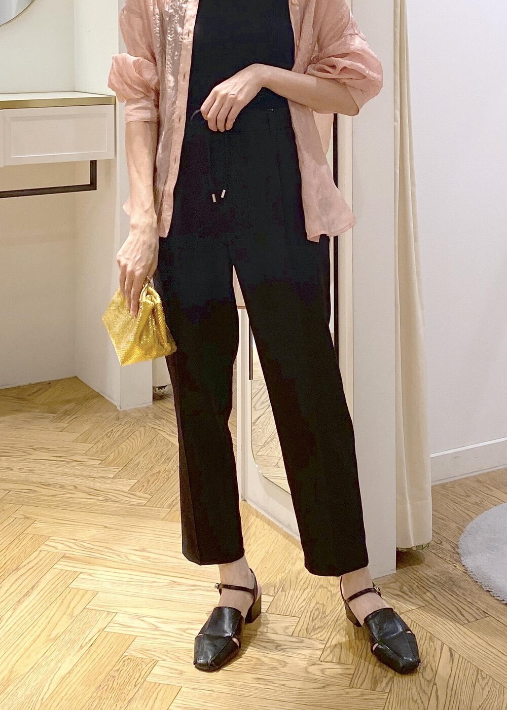 ブラック系のサンダル、ブラック系のスラックス、ブラック系のキャミソールを着用したレディースの夏コーディネートの4枚目の写真