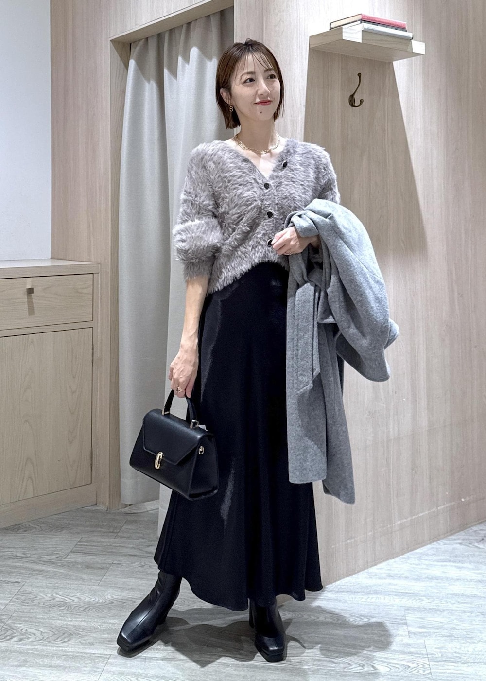 グレー系のカーディガン/ボレロ、グレー系のその他アウター、ブラック系のブーツを着用したレディースの冬コーディネートの2枚目の写真