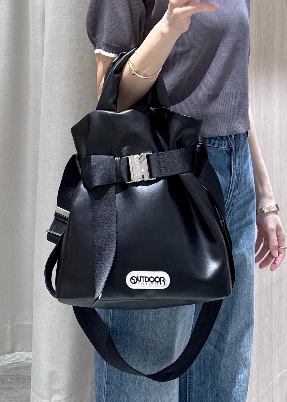 ホワイト系のキャミソール、ブラック系のトートバッグ、ブルー系のデニムパンツを着用したレディースの春コーディネートの9枚目の写真