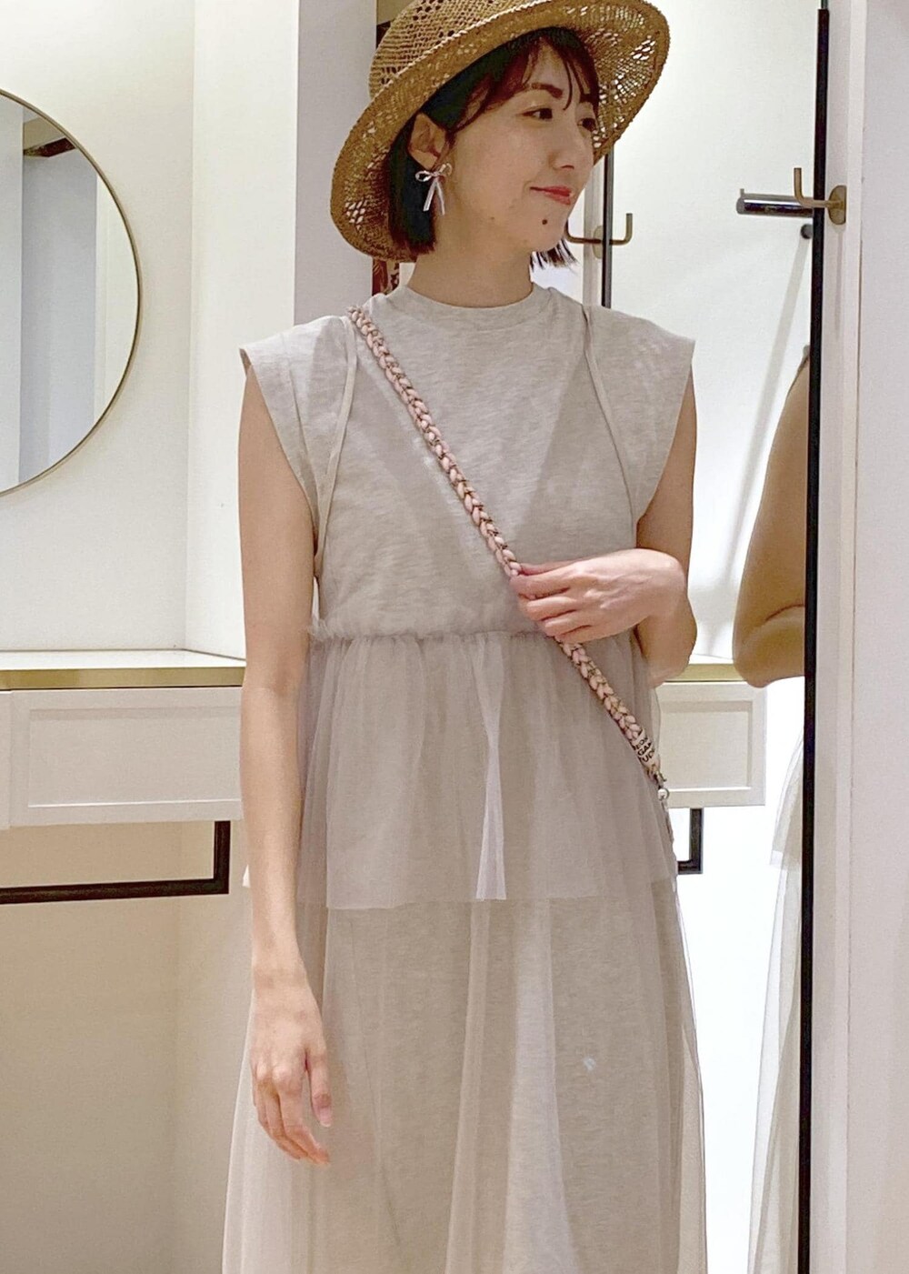 ブラック系のキャミソール、シルバー系のトートバッグ、ホワイト系のワンピースを着用したレディースの春コーディネートの4枚目の写真