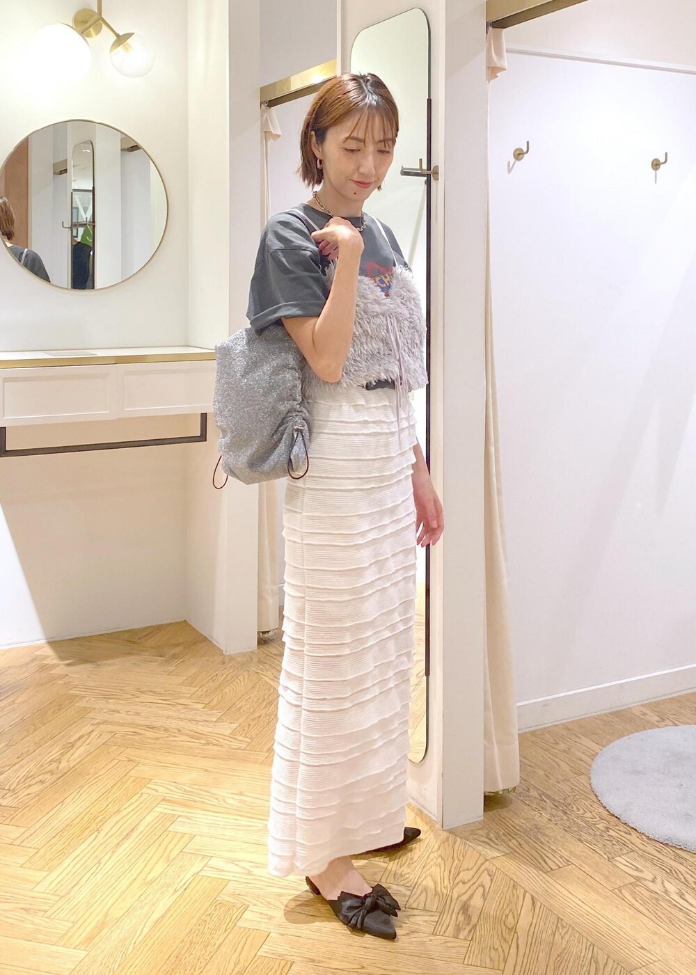 ホワイト系のスカート、シルバー系のショルダーバッグ、グレー系のキャミソールを着用したレディースの夏コーディネートの5枚目の写真