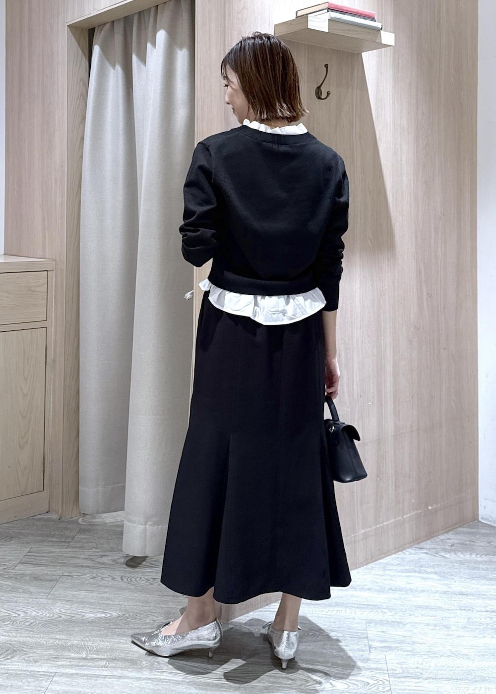 シルバー系のパンプス、ブラック系のショルダーバッグ、ブラック系のスカートを着用したレディースの冬コーディネートの4枚目の写真