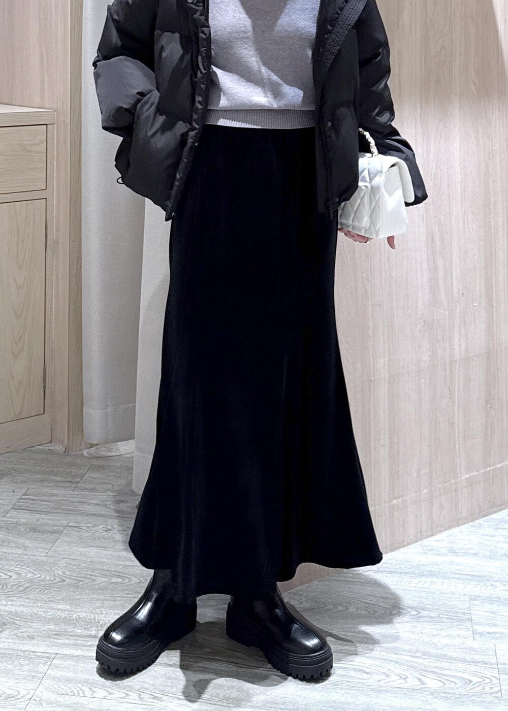 ブラック系のブーツ、ブラック系のスカート、ブラック系のダウンジャケット/コートを着用したレディースの冬コーディネートの4枚目の写真